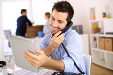 Homem ao telefone usando um Tablet