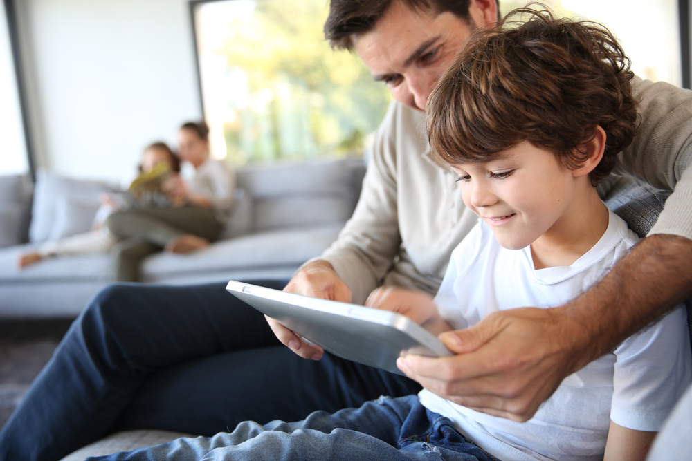 homem mostrando tablet para criança