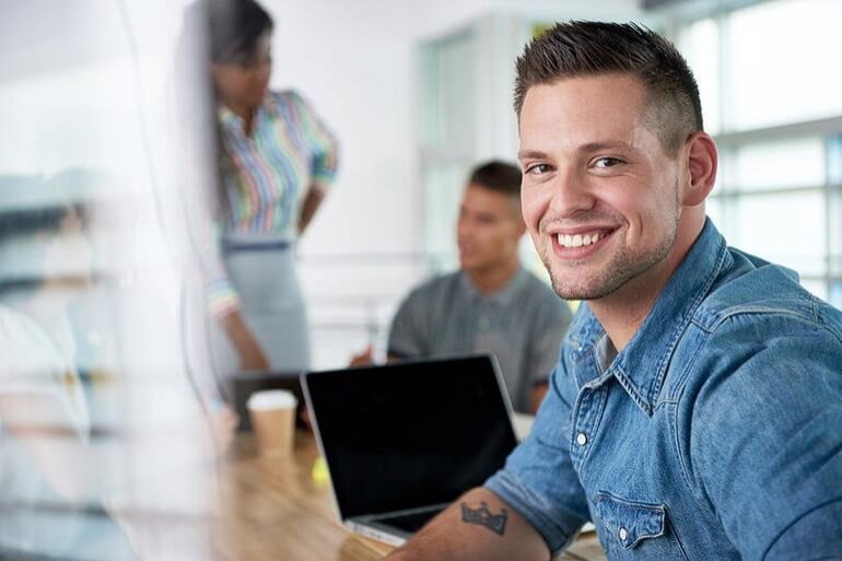 homem sorrindo em uma sala de reuniões