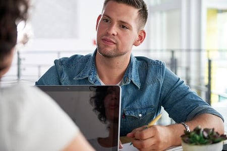 Image of two succesful business people using a laptop during conversation