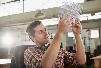 homem analisando um cubo em um escritório