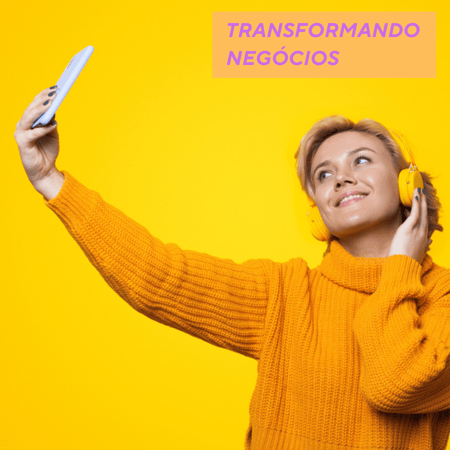 Mulher com fone laranja sorrindo e tirando selfie