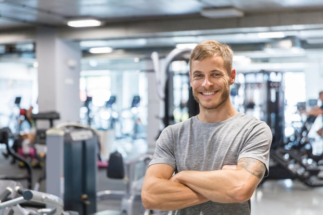 homem de braços cruzados em uma academia