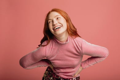 Mulher sorridente com mãos na cintura