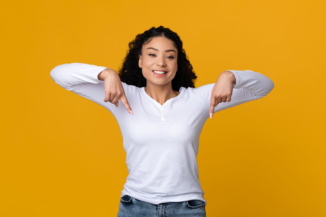 mulher com blusa branca apontando para baixo