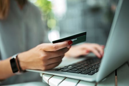 Mulher fazendo uma compra com cartão de crédito pelo notebook