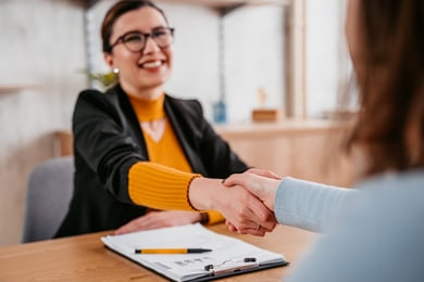 Duas mulheres se cumprimentando em uma mesa