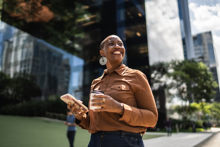 Mulher na frente de prédio sorrindo