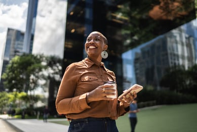 mulher na frente de prédio sorrindo