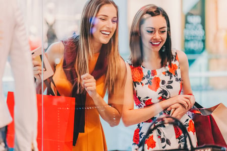 mulheres sorrindo olhando uma vitrine