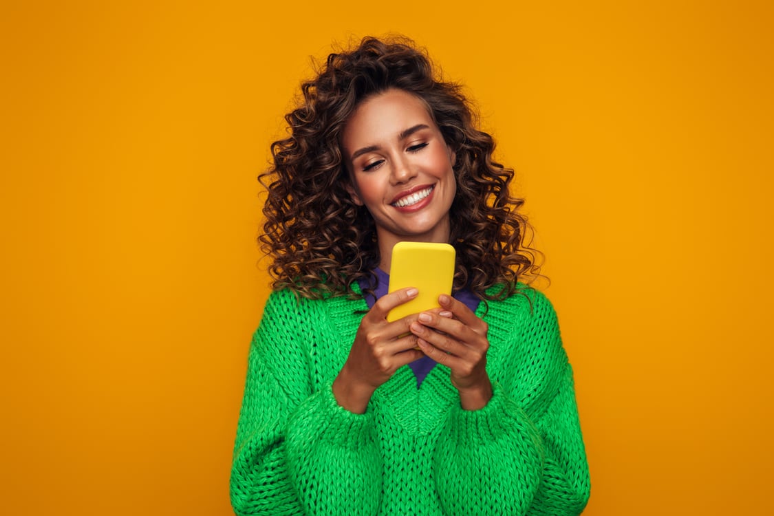 mulher sorrindo segurando celular