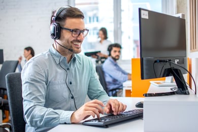 Homem de Telemarketing usando computador sorrindo