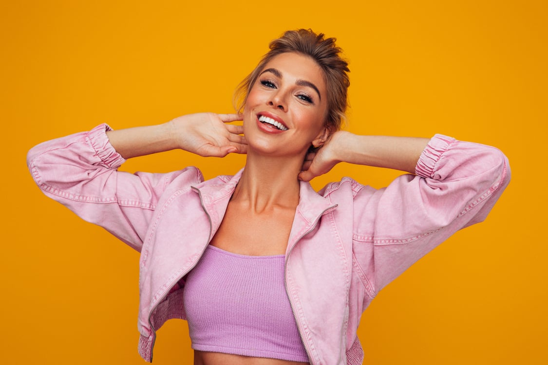 mulher sorrindo com mãos na nuca 