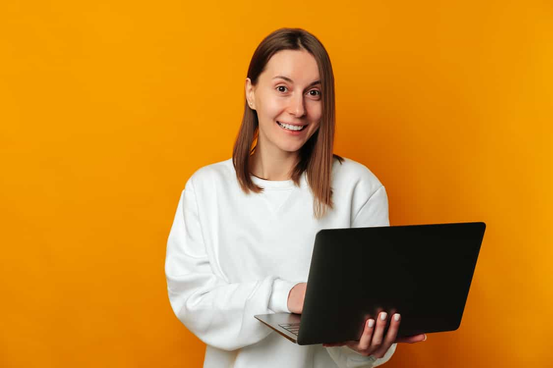 Mulher sorrindo com notebook na mão