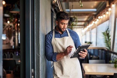 homem no restaurante mexendo no tablet