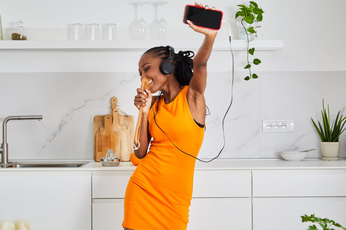 mulher na cozinha ouvindo música no fone de ouvido