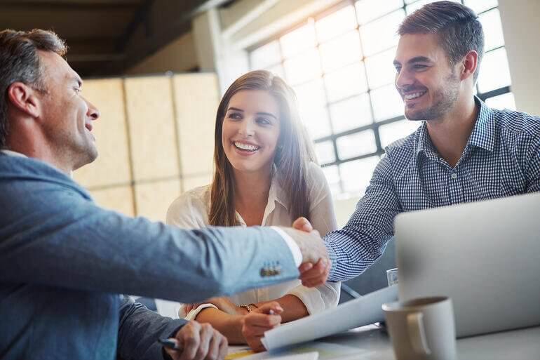 pessoas fechando negócio em uma reunião