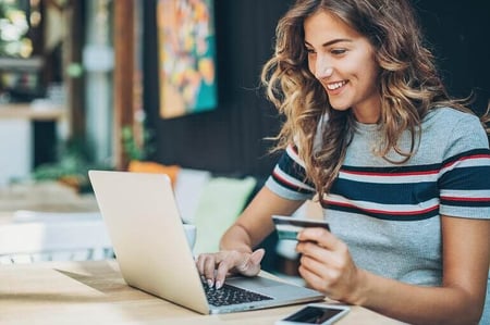 mulher com cartão de crédito no computador