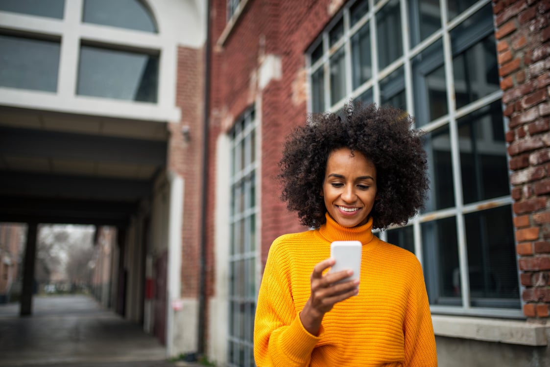 Mulher sorrindo Olhando celular na rua