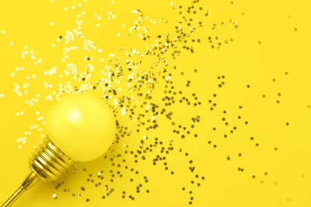 Lampada em fundo amarelo com pequenas estrelas