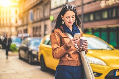 mulher na rua segurando o celular